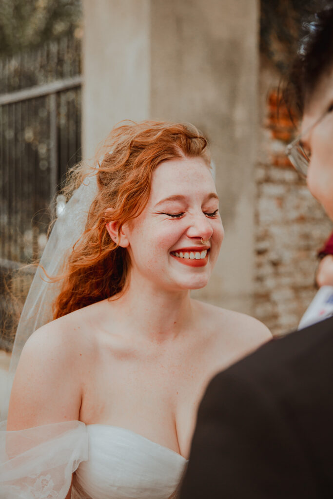 woman smiling at her new husband during her wedding ceremony in downtown charleston