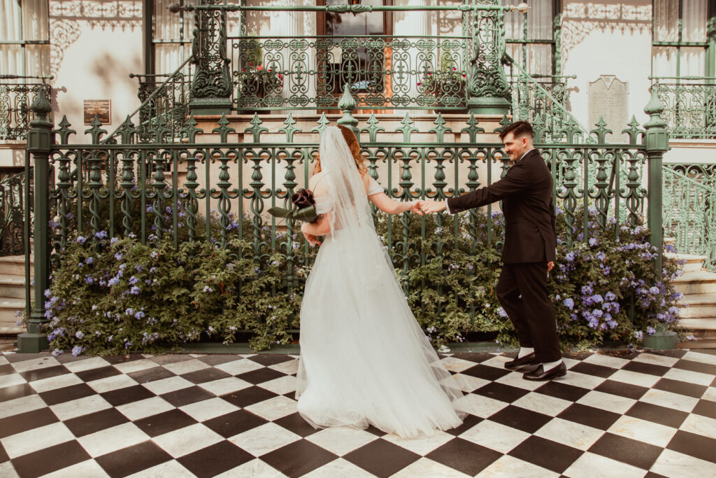 bride leading groom in front of the Rutledge Inn in downtown Charleston