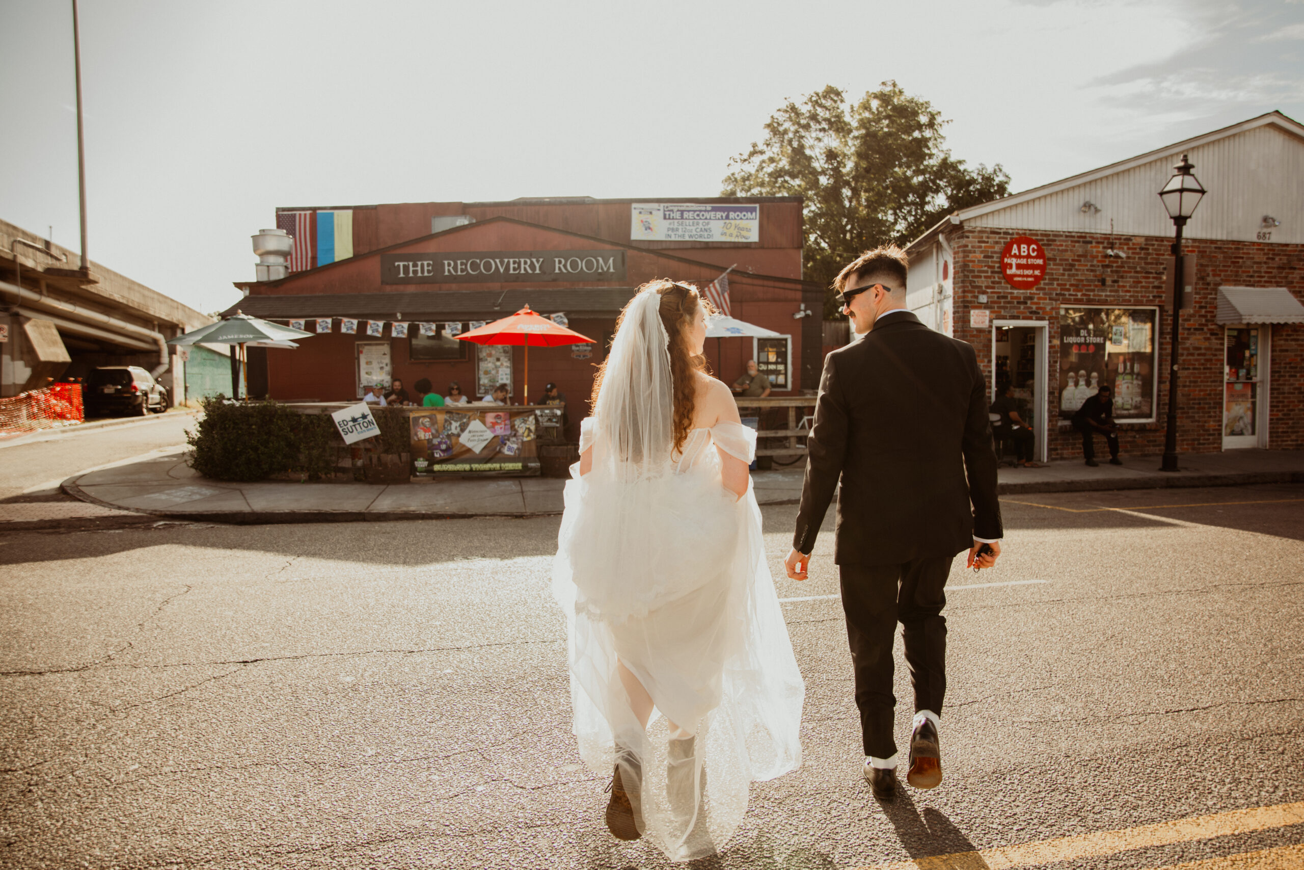 couple walking across street to a Charleston dive bar