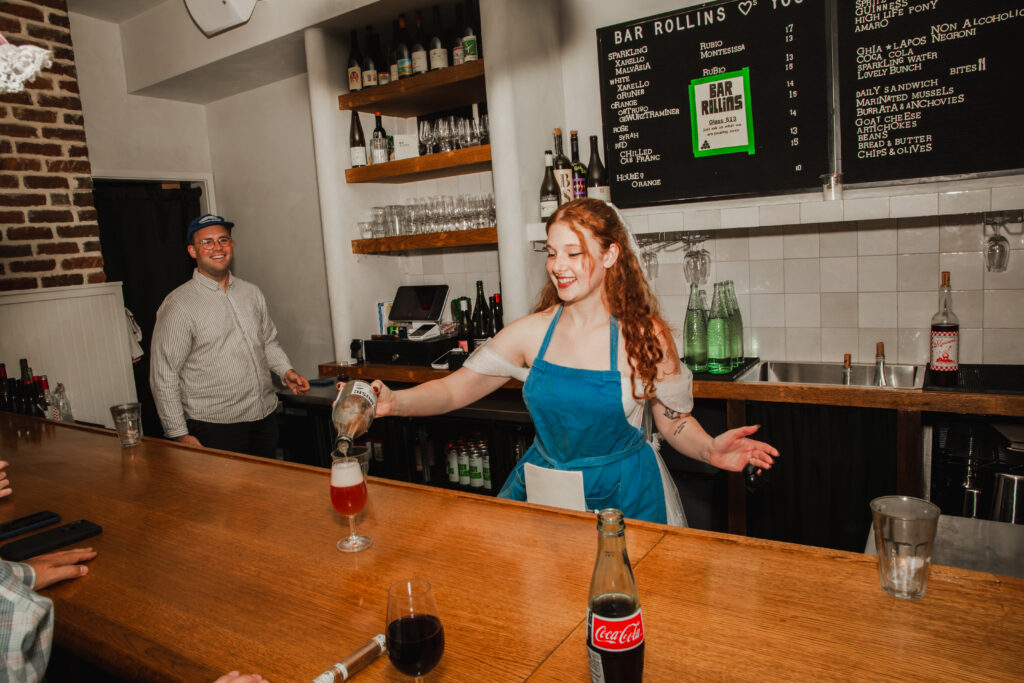 bride wearing a blue apron and pouring wine in downtown Charleston