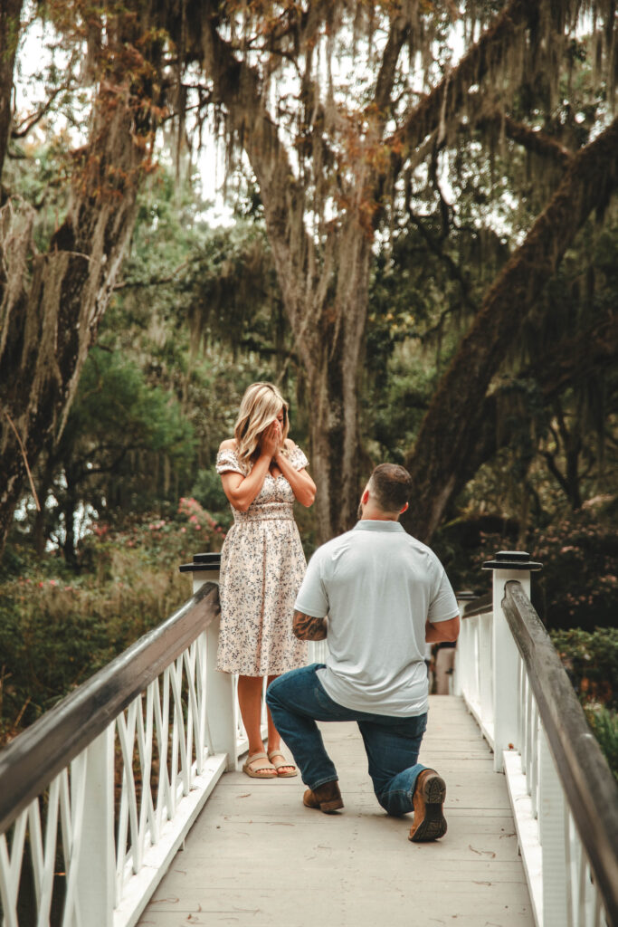 man proposing to woman on a white bridge at Magnolia plantation and gardens