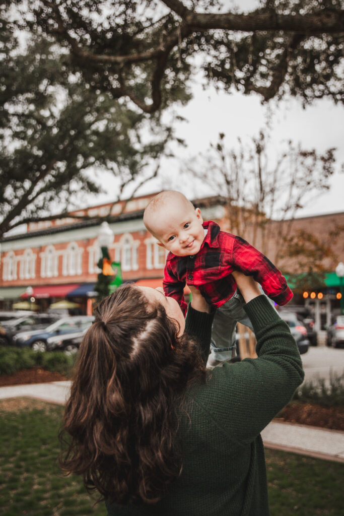 mom holding up baby sticking her tongue out in Summerville SC