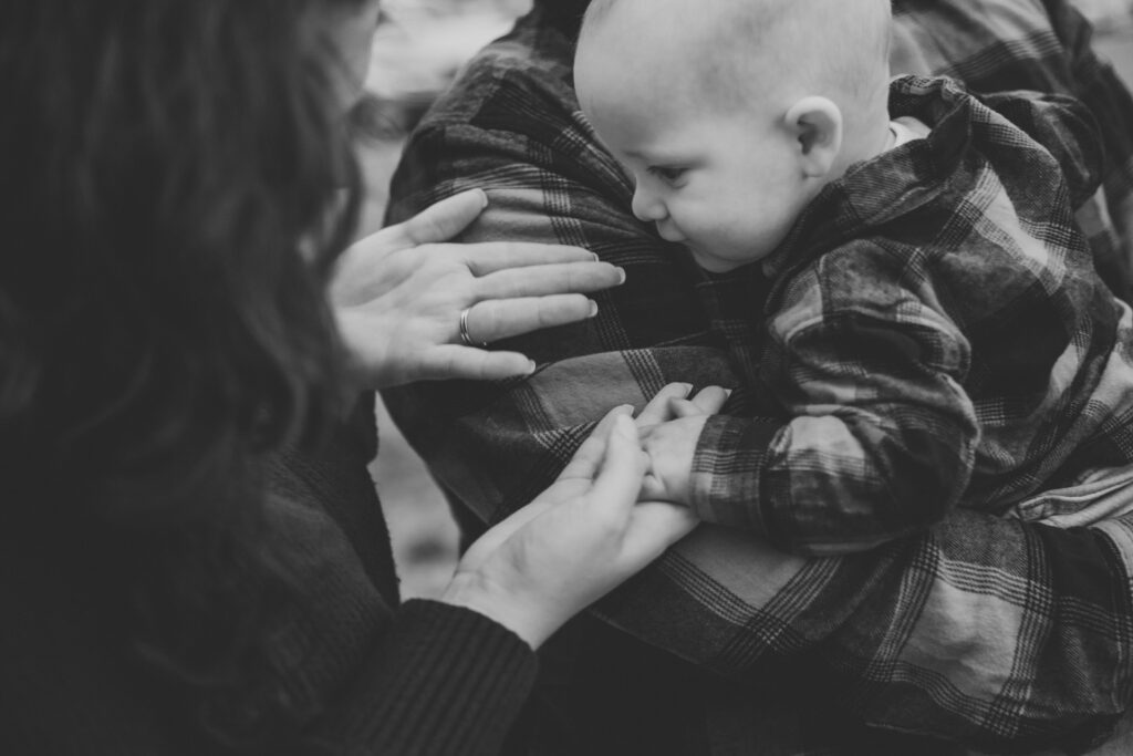 black and white image of mom reaching for baby in Charleston SC