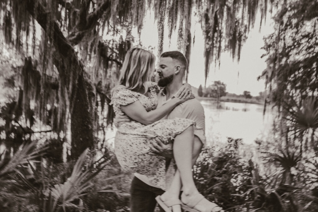 man holding woman at magnolia plantation under spanish moss in the rain