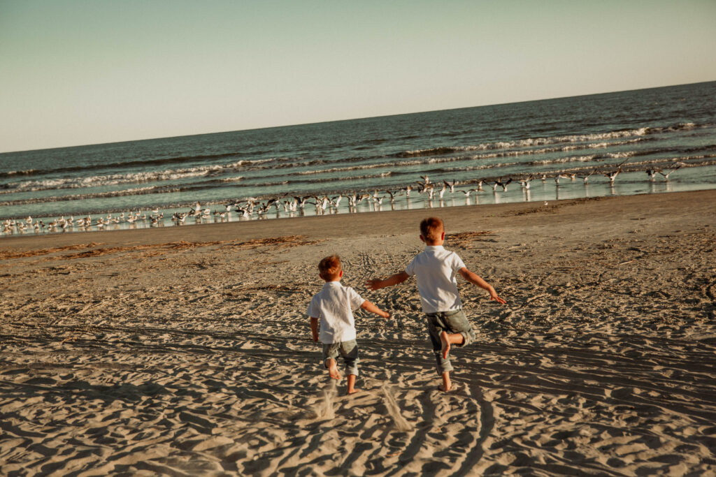 two brothers running toward a group of seagulls at Kiawah Island Resort