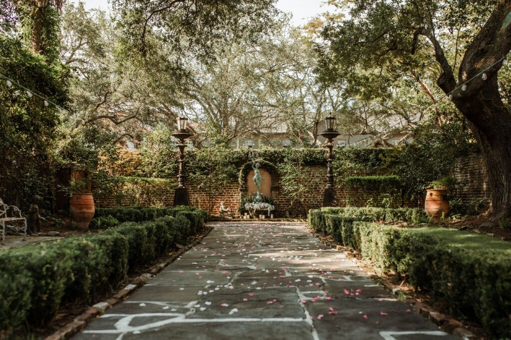 Rose petals scattered along a stone walkway between manicured hedges at Charleston’s 20 South Battery.