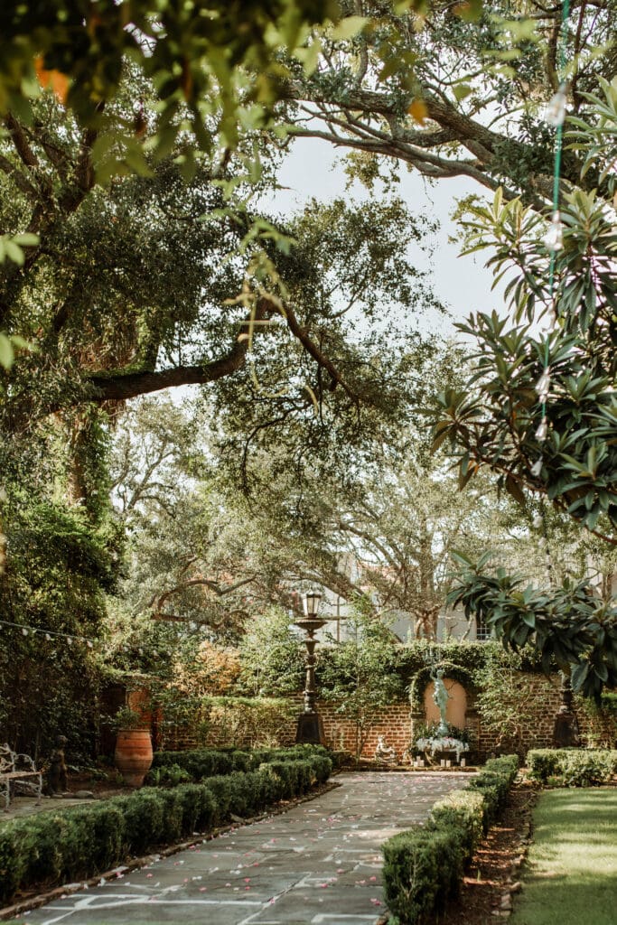 Overhanging trees frame the courtyard garden and proposal setup at 20 South Battery in Charleston